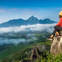 A girl sitting on hills and enjoying the view