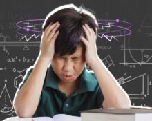 a boy holding his head while studying math