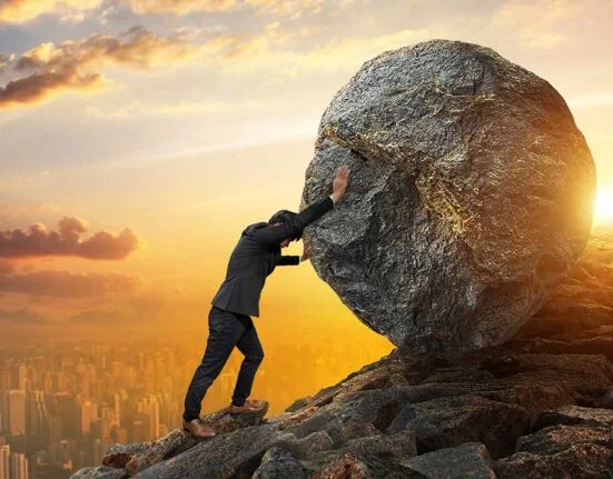 a man pushing a big stone